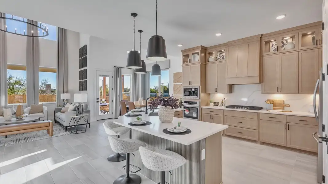 Sophisticated kitchen boasts sleek cabinetry, island seating, and expansive windows in Creeks Crossing location.