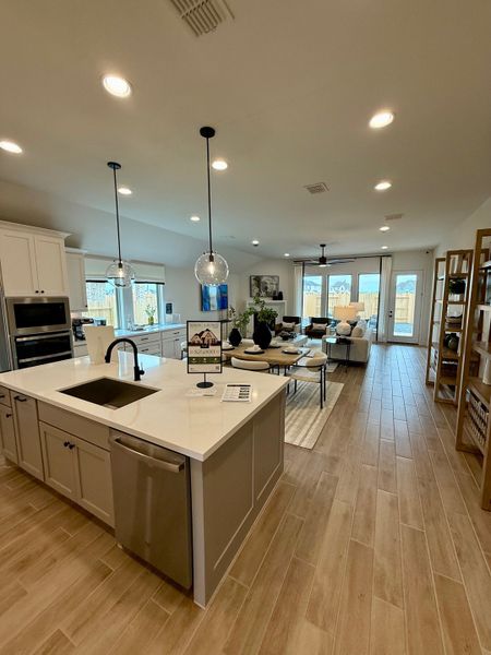 A modern kitchen with sleek island, pendant lighting, and open floor plan to the living area. Perfect for entertaining. A modern kitchen with sleek island, pendant lighting, and open floor plan to the living area. Perfect for entertaining.