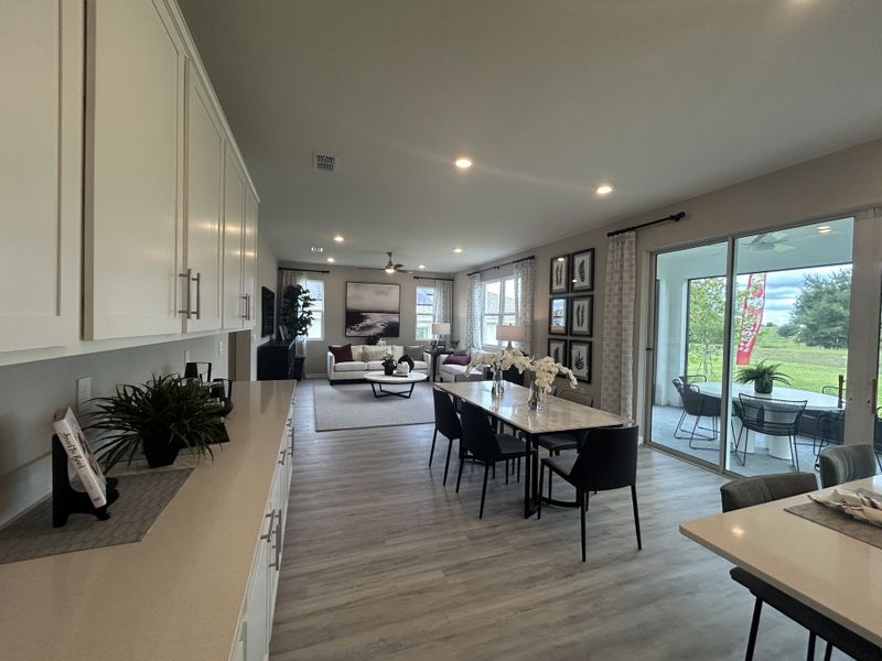 An inviting open-concept living space with elegant cabinetry, modern furnishings, and a scenic view through glass doors. An inviting open-concept living space with elegant cabinetry, modern furnishings, and a scenic view through glass doors.