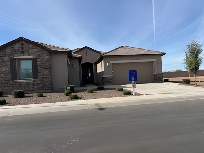 A charming stone-accented home with a spacious driveway in Bella Vista Farms: Premier by Lennar (San Tan Valley, AZ).