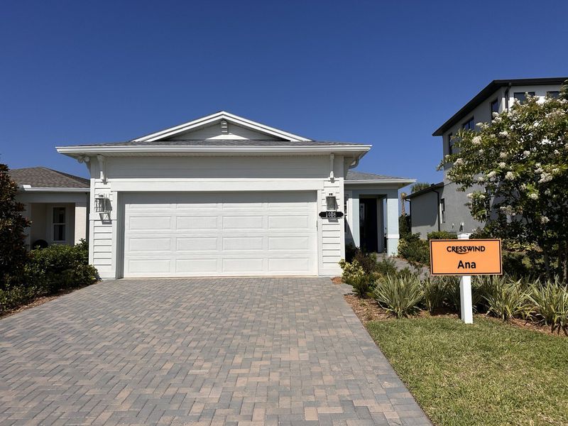 A charming white home with a spacious paved driveway in Cresswind at Lake Harris by Kolter Homes (Tavares, FL).