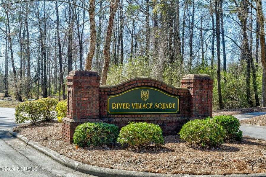 Entrance to the River Village Square in River Landing community in Wallace, NC, featuring signage and landscaping (Image 1).