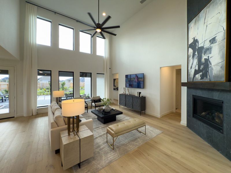 A spacious living room with high ceilings, large windows, and modern furnishings. A spacious living room with high ceilings, large windows, and modern furnishings.