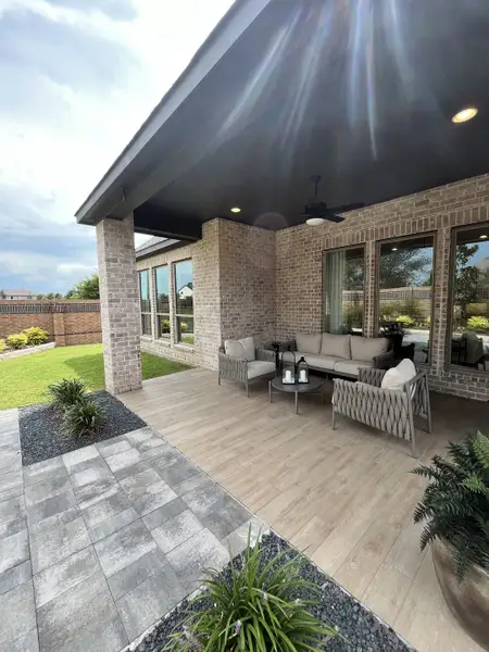 A stylish patio with cozy seating, modern tiles, and greenery. Perfect for outdoor relaxation and entertaining guests.