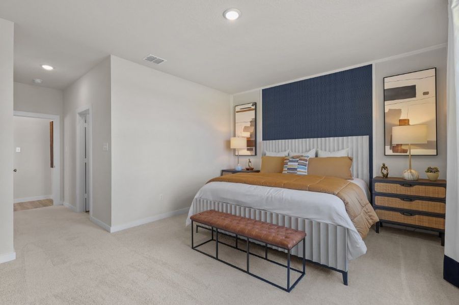 A bedroom with a bed and a bench.