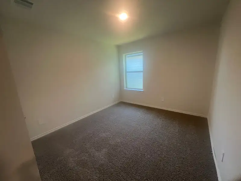 A cozy bedroom with soft carpeting, neutral walls, and a single window allowing natural light to fill the space. A cozy bedroom with soft carpeting, neutral walls, and a single window allowing natural light to fill the space.