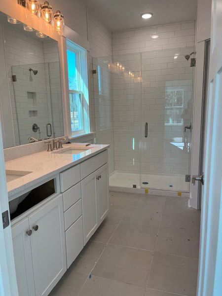 A modern bathroom with subway-tiled shower, elegant vanity, and ambient lighting.