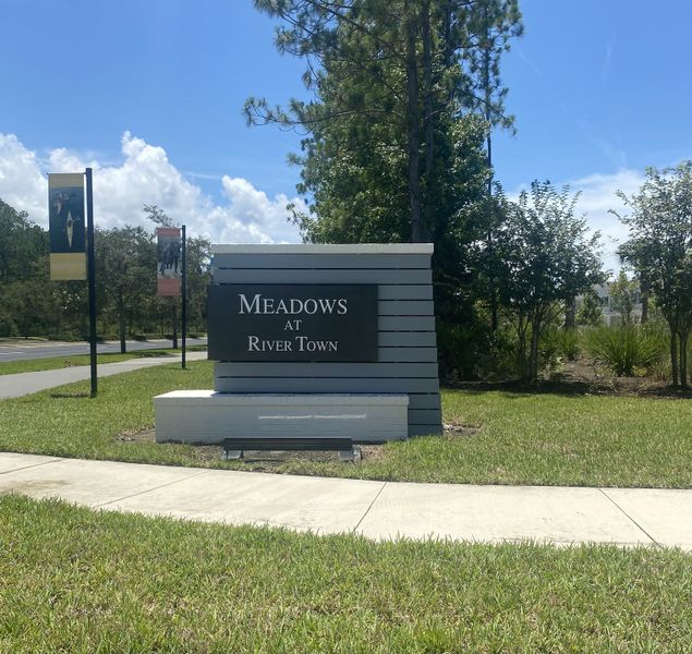 A welcoming entrance sign to RiverTown - Meadows by Mattamy Homes in St. Johns, FL, surrounded by lush greenery.