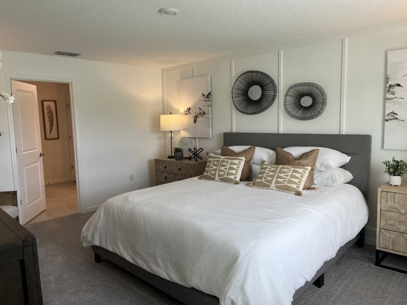 A cozy bedroom featuring a plush bed, decorative wall art, and elegant nightstands with soft lighting. A cozy bedroom featuring a plush bed, decorative wall art, and elegant nightstands with soft lighting.