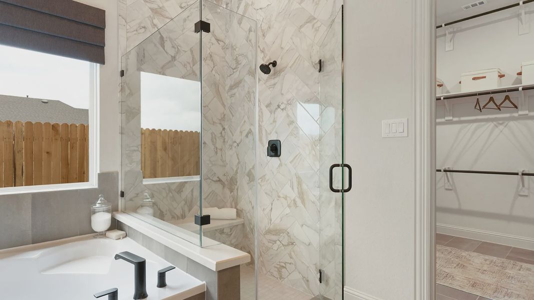 Hand-laid ceramic tile shower with frameless glass and black hardware for a sleek, modern finish.