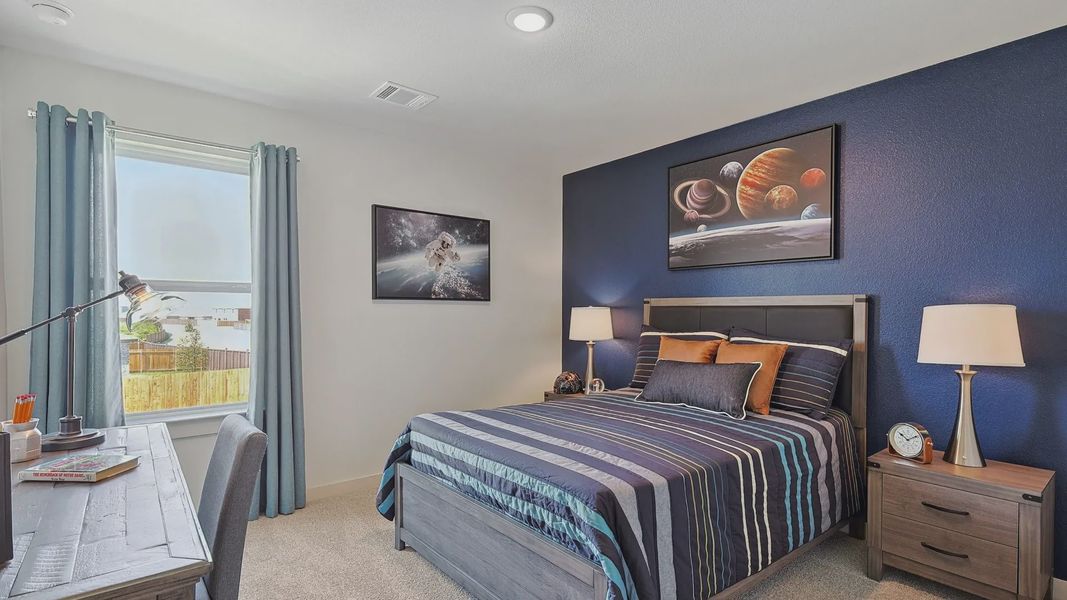 Elegant bedroom features rich blue accent wall, luxury wood furniture, and space art in Patriot Estates. Elegant bedroom features rich blue accent wall, luxury wood furniture, and space art in Patriot Estates.