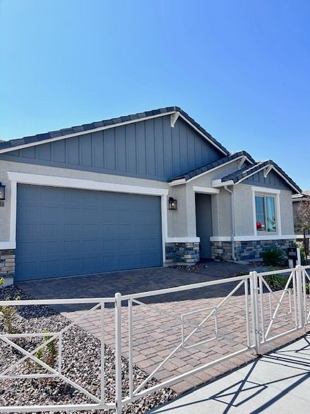 A modern gray and white home with a landscaped front yard in Seasons at Laveen Vistas by Richmond American Homes (Phoenix, AZ).