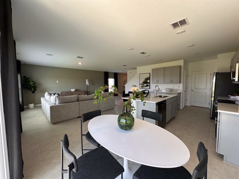 A modern open-concept living area with a cozy sectional sofa, sleek kitchen, and stylish dining setup.