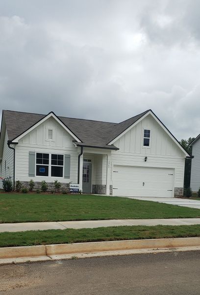 A charming white home with stone accents and lush lawn in Fairhaven by D.R. Horton (Lithia Springs, GA).