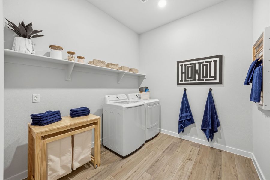 A room with a table and a shelf with clothes on it. A room with a table and a shelf with clothes on it.