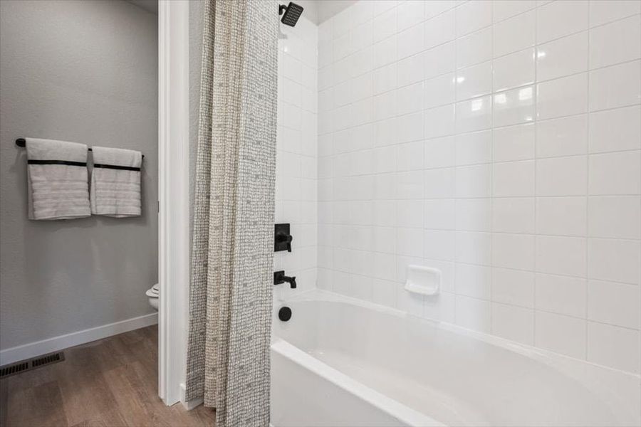 A bathroom with a bathtub and toilet.