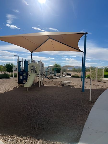 A sun-shaded playground in Rio Rancho Estates by D.R. Horton, offering family-friendly amenities in Surprise, AZ.