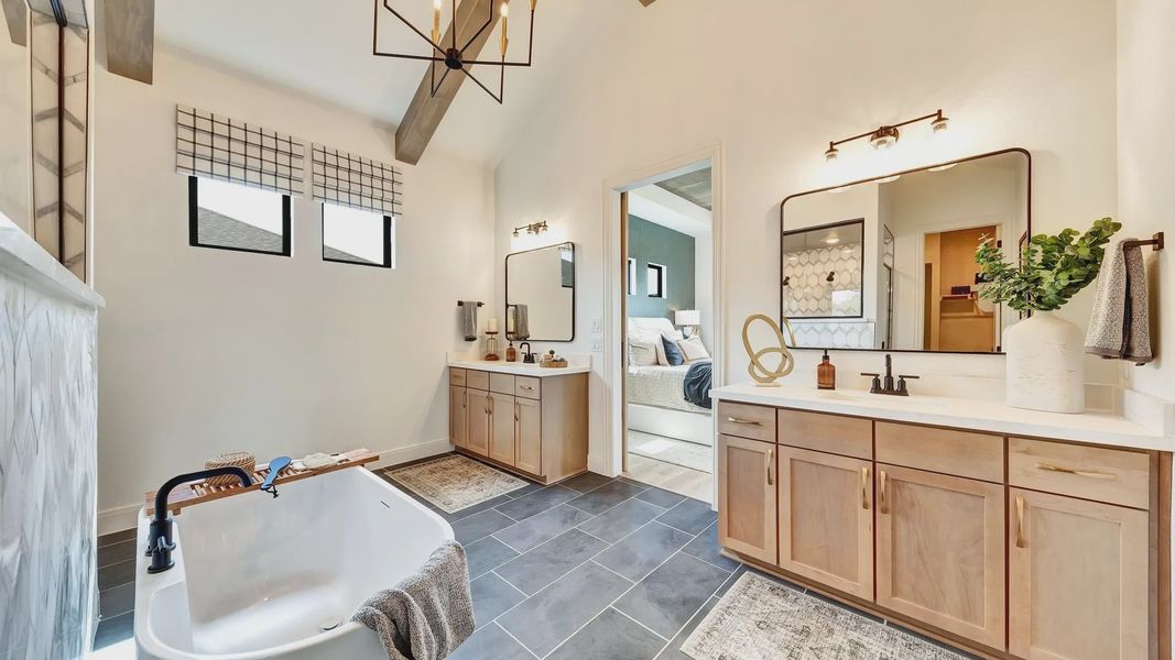 Spa-inspired primary bath featuring a freestanding soaking tub, designer tile, and vaulted ceilings Spa-inspired primary bath featuring a freestanding soaking tub, designer tile, and vaulted ceilings