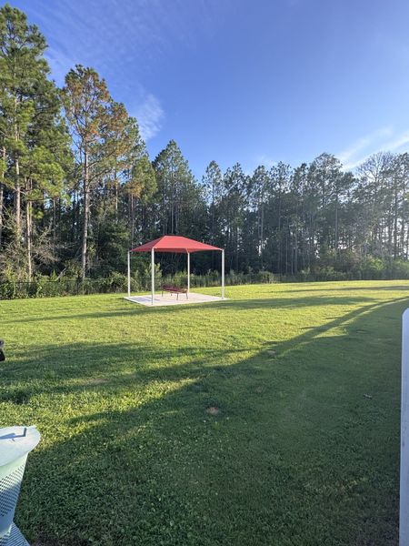 A serene outdoor space with a gazebo surrounded by lush greenery in The Preserve at Bannon Lakes by Pulte Homes (St. Augustine, FL).