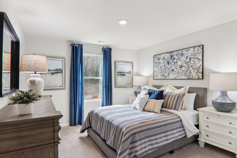 A bedroom with a bed and blue curtains.