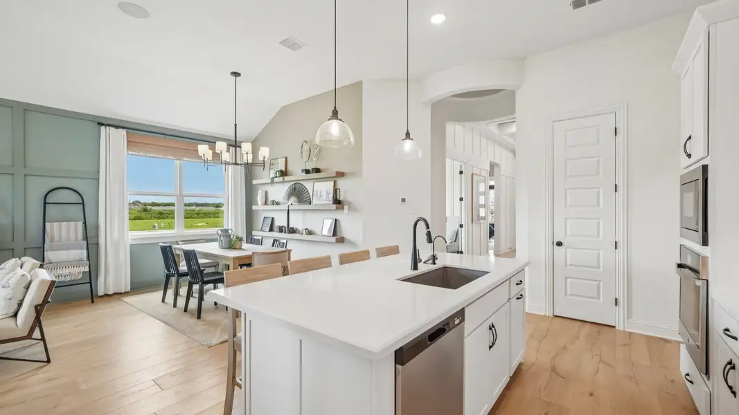Elegant kitchen with gray scalloped backsplash, glass pendant lighting, center island, and ambient accent lighting Elegant kitchen with gray scalloped backsplash, glass pendant lighting, center island, and ambient accent lighting