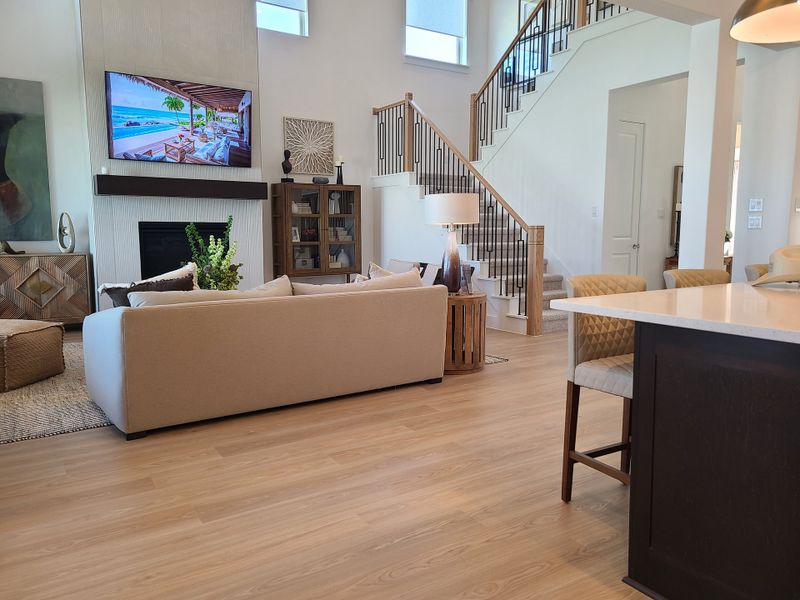 A spacious living area with cozy seating, a modern staircase, and a sleek kitchen island. Perfect for entertaining guests. A spacious living area with cozy seating, a modern staircase, and a sleek kitchen island. Perfect for entertaining guests.