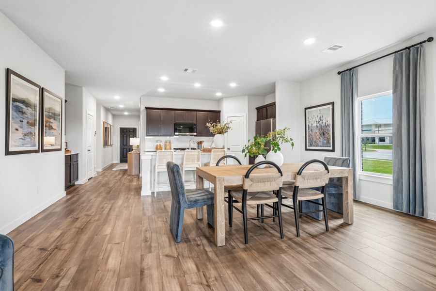 A dining room with a table and chairs.