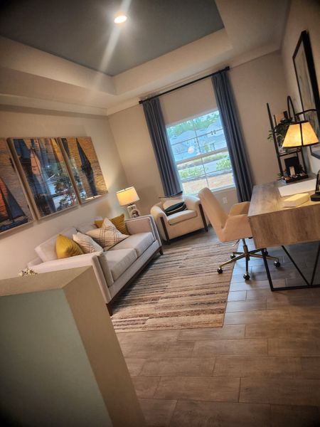 A cozy home office with a chic sofa, elegant desk, and stylish decor. Warm tones and natural light create an inviting atmosphere.