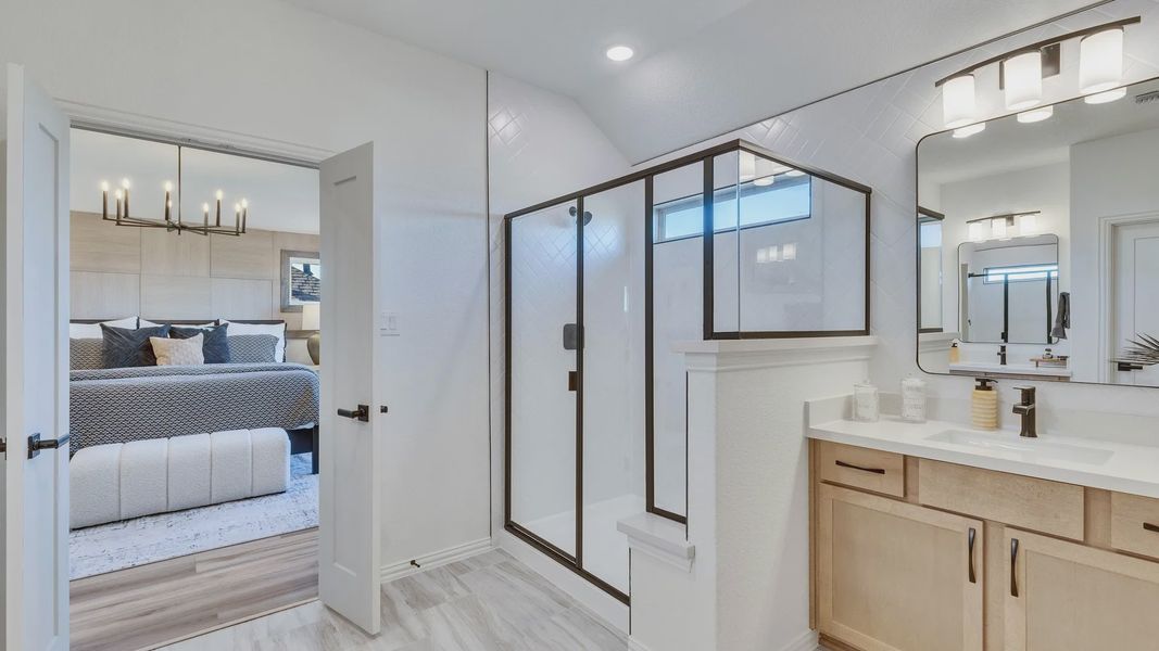 This Briarwood bathroom boasts a sleek glass shower and custom wood cabinetry, epitomizing elegant craftsmanship.