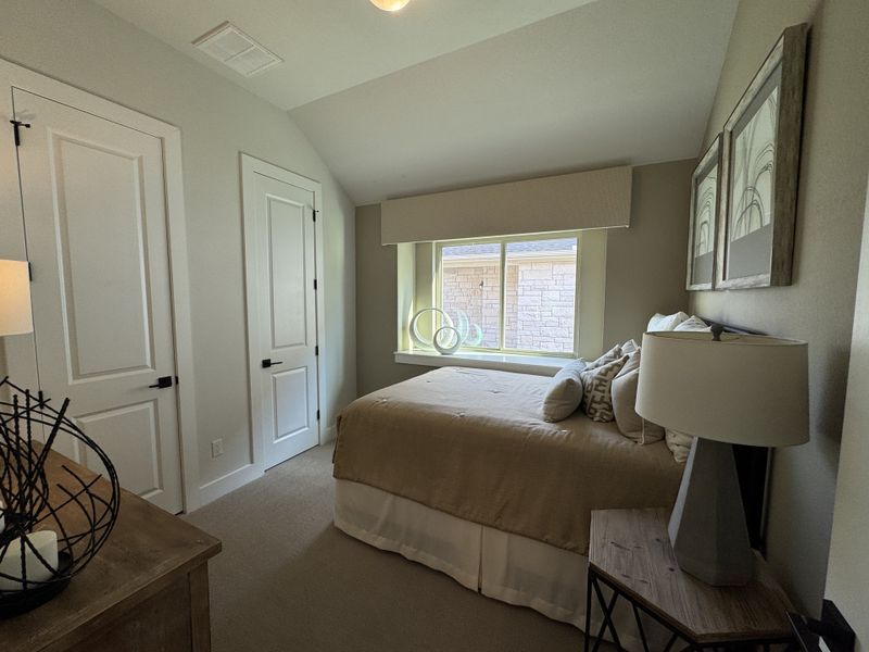 A cozy bedroom featuring soft neutral tones, a large window, and elegant modern decor.