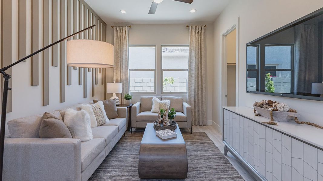 Textured wall panels and sleek furniture enhance this Windrose living room, offering upscale sophistication.