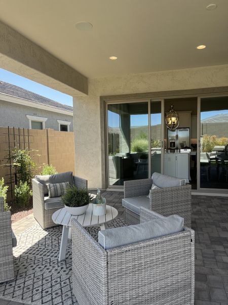 A cozy patio with wicker seating, a patterned rug, and a lovely view to the outside. Perfect for relaxing and entertaining.