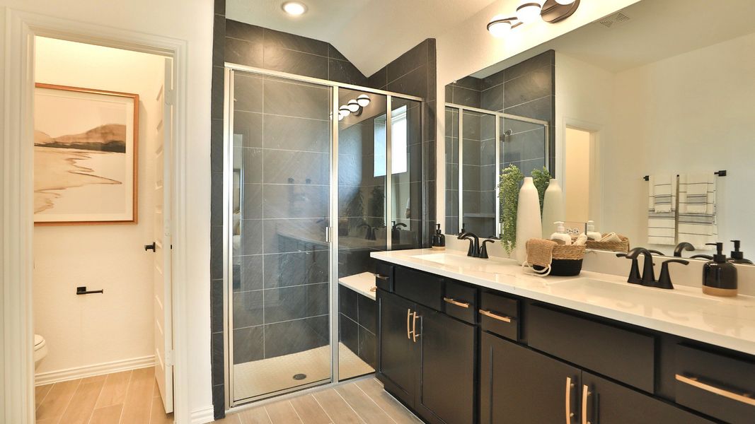 Bridgeland bath boasts exquisite glass shower, chic dark cabinetry, and refined lighting. Elegant above all. Bridgeland bath boasts exquisite glass shower, chic dark cabinetry, and refined lighting. Elegant above all.