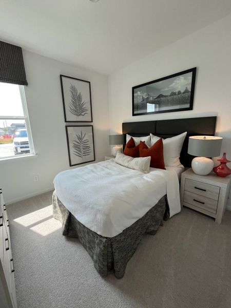 A cozy bedroom featuring a plush bed, modern artwork, and soft natural light filtering in through the window. A cozy bedroom featuring a plush bed, modern artwork, and soft natural light filtering in through the window.