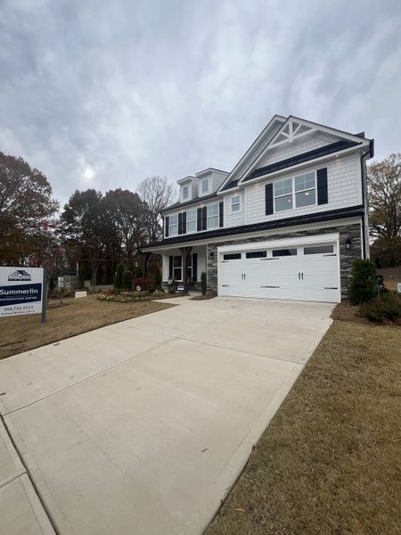 A charming white two-story home with a spacious driveway in Summerlin by Eastwood Homes (Mooresville, NC).