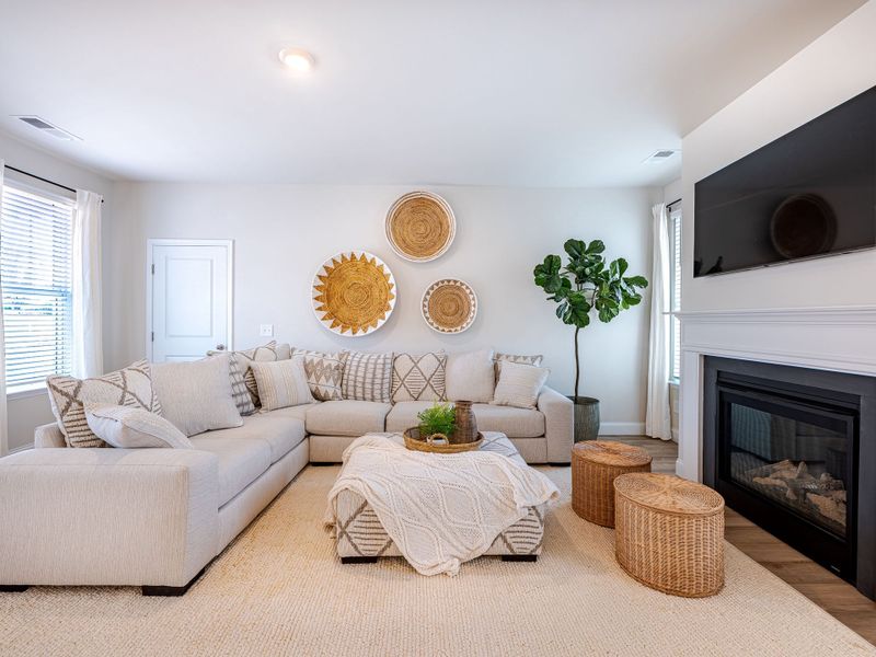 The living room is open to the kitchen and dining room with an entrance to the outside patio space.