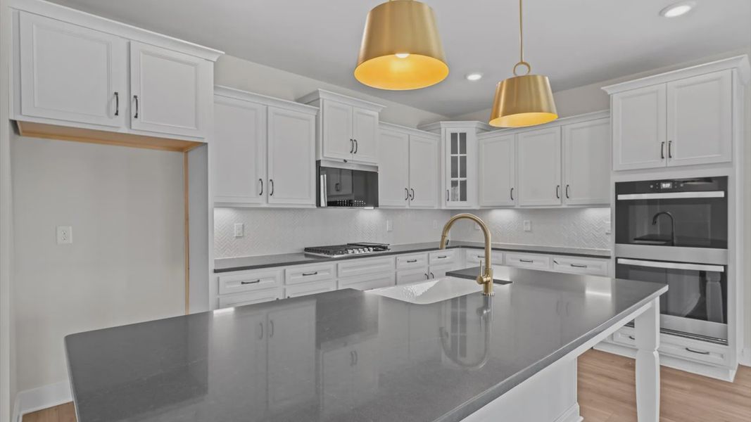 Kitchen with white cabinets, large island, and farmhouse sink