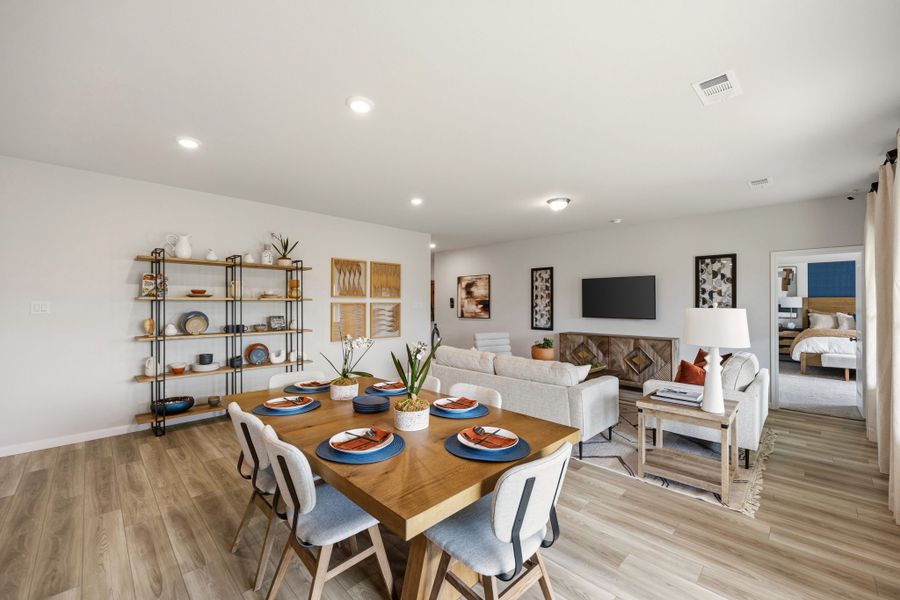 A large living room with a dining table and chairs. A large living room with a dining table and chairs.
