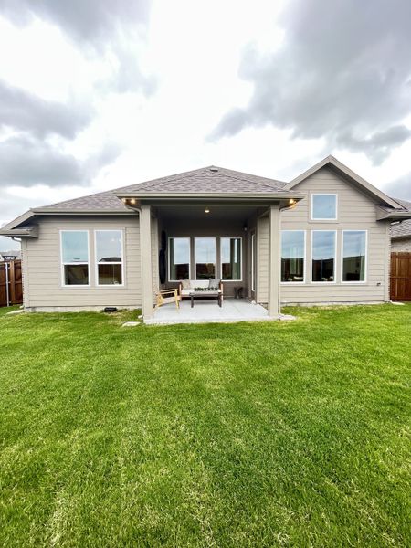 A charming modern home with large windows and a lush backyard in Elevon by Pacesetter Homes (Lavon, TX).