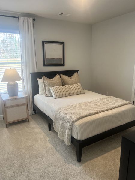 A cozy bedroom features a dark wood platform bed with neutral bedding, complemented by a matching nightstand and a framed abstract artwork. A cozy bedroom features a dark wood platform bed with neutral bedding, complemented by a matching nightstand and a framed abstract artwork.