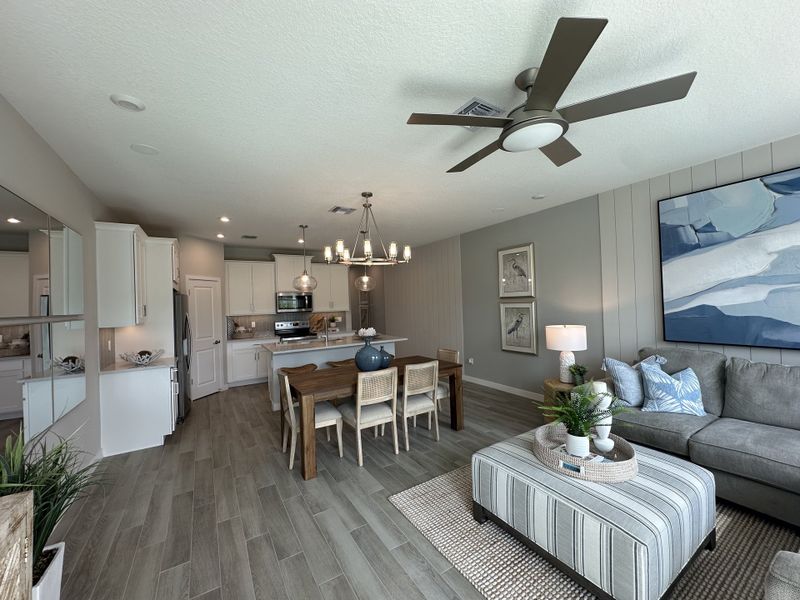 A modern open-plan living area with sleek kitchen, cozy seating, and stylish decor in neutral tones.