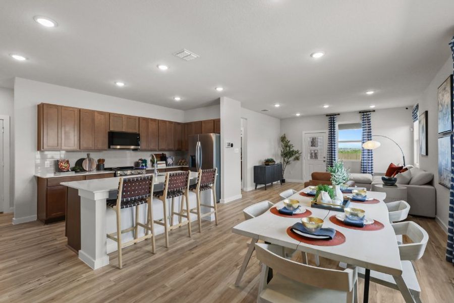 A kitchen with a dining table and chairs.