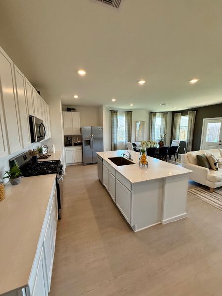 A spacious kitchen with white cabinetry, a central island, and stylish dining area.