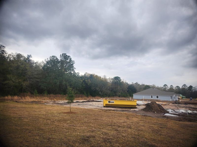 A developing site in Creekside Landing by Maronda Homes, featuring a construction area and trees in Callahan, FL.