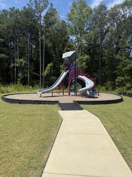 A welcoming playground with slides and lush greenery in Campground Crossing by Dream Finders Homes (Mcdonough, GA). A welcoming playground with slides and lush greenery in Campground Crossing by Dream Finders Homes (Mcdonough, GA).