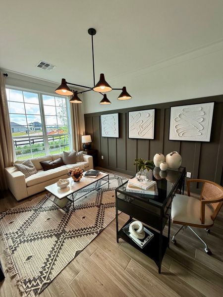 A cozy living room with a plush sofa, geometric rug, modern lighting, and stylish wall art.