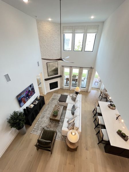 A spacious living room with a high ceiling, elegant seating, large windows, and open layout, blending modern comfort and style.