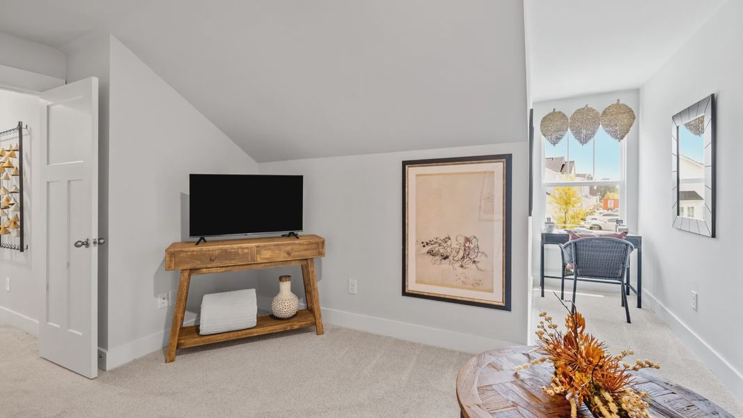 Cozy carpeted loft space with gray walls and large window at Aspen Ridge by DRB Homes in Lyman, SC Cozy carpeted loft space with gray walls and large window at Aspen Ridge by DRB Homes in Lyman, SC