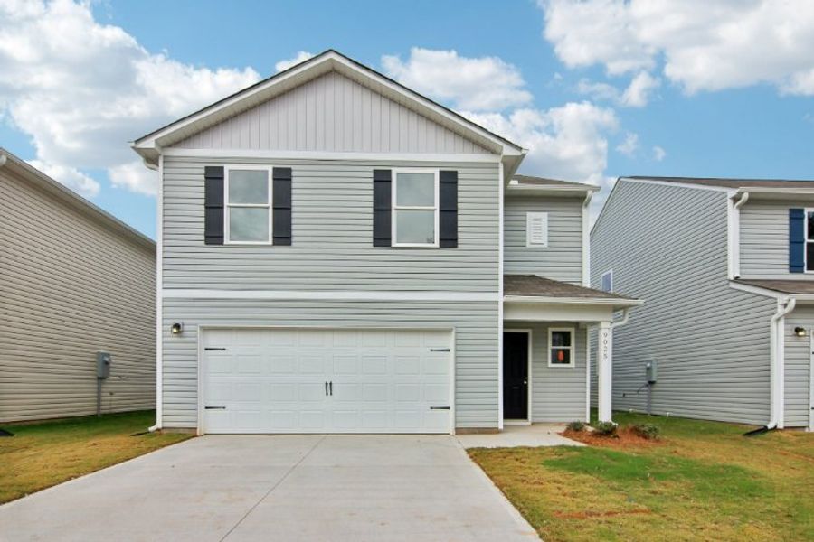 A white house with a garage with Rockingham Meeting House in the background.