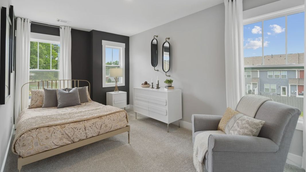 Plush carpeted secondary bedroom with elevated ceilings and large windows at Tyger Ridge by DRB Homes Plush carpeted secondary bedroom with elevated ceilings and large windows at Tyger Ridge by DRB Homes